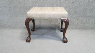 A Georgian style mahogany stool in striped floral upholstery with shell carved ball and claw