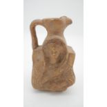 A glazed ceramic jug with a relief design of a cloaked figure. H.17cm