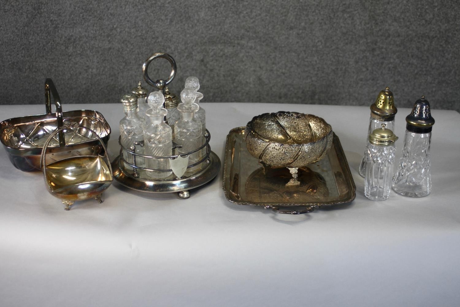 A collection of silver plate. Including a twin handled serving tray, a cut crystal cruet set, a