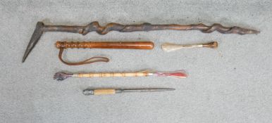 A collection of wooden items. Including a walking stick, a wooden truncheon, a shoe horn and a