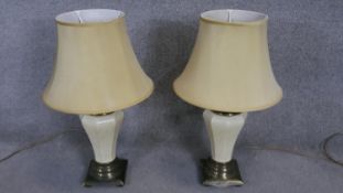 A pair of vintage brass and white crackle glaze ceramic table lamps with cream shades. H.74cm