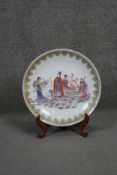 A Chinese hand painted famille rose porcelain charger with stand. Depicting the Emperor and his