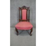 A mid 19th century rosewood nursing chair with carved top rail and barleytwist supports on carved