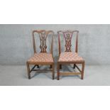 A pair of Georgian mahogany dining chairs with drop in seats on square stretchered supports.