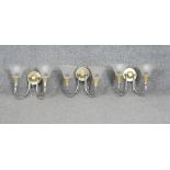 Three two branch silver and gold tone metal wall lights with frosted conical shades. H.24 W.30 CM
