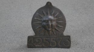 A lead Sun firemark insurance plaque, with rising sun in a disc over rectangular panel and impressed