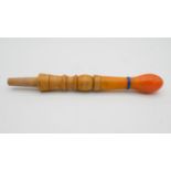 A carved wooden hookah pipe with a orange plastic end. L.24cm