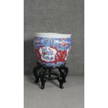 A contemporary Chinese hand painted porcelain goldfish bowl on ebonised stand. Decorated with