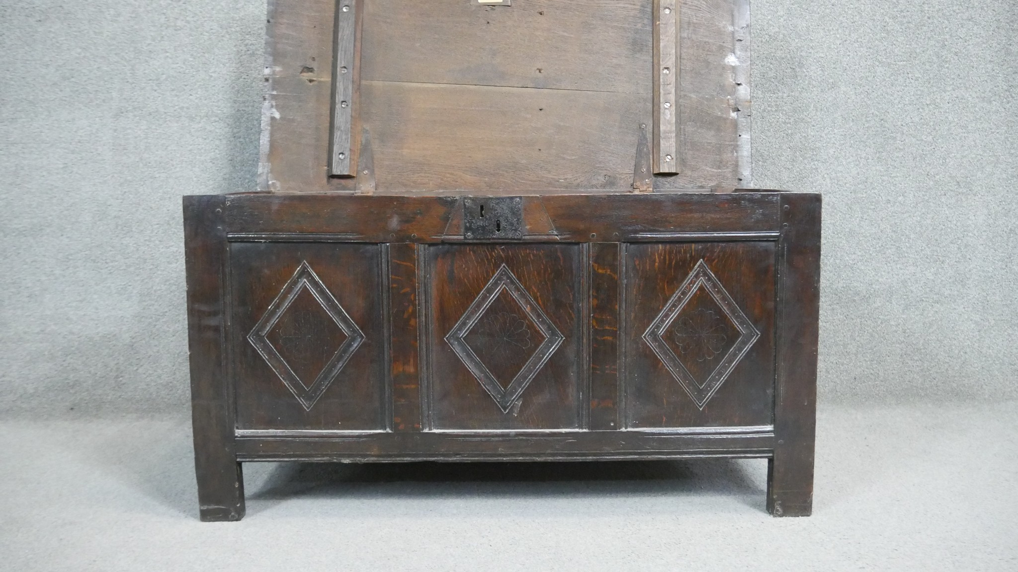 A 17th century oak coffer with lozenge carved panels raised on stile supports. H.54 W.104 D.49cm - Image 5 of 11