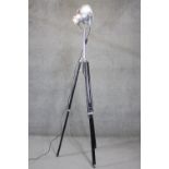A height adjustable vintage Strand Electric chrome theatre spotlight on black tripod base. Maker's