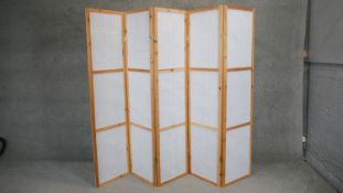 A pine framed four fold room divider with five opaque paper panels. H.175 x W.225cm