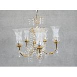 An eight branch brass and crystal chandelier with etched design shades. Diam.45cm