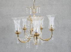 An eight branch brass and crystal chandelier with etched design shades. Diam.45cm