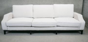 A large contemporary sofa in piped pale grey upholstery on square tapering ebonised supports. H.