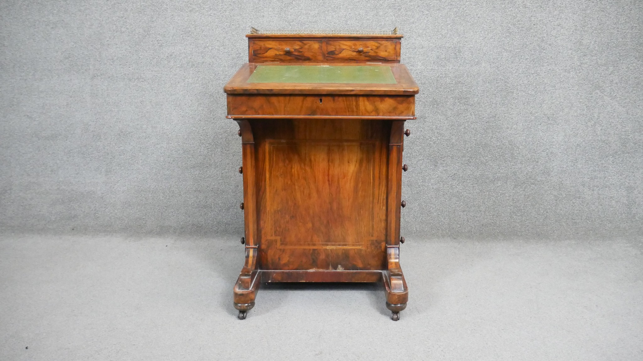 A 19th century figured walnut Davenport with brass galleried and fitted superstructure above leather