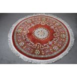A red ground hand made woollen Chinese circular carpet. Diam. 190cm