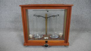 A wooden and glass cased set of brass analytical lab balance scales. H.40 W.43 D.20cm