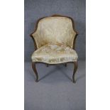 A mid century Continental style mahogany framed armchair in floral damask upholstery raised on