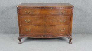 A mid century Georgian style mahogany serpentine fronted chest of drawers on carved cabriole ball