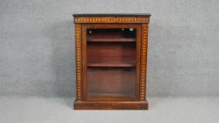 A 19th century rosewood and satinwood inlaid pier cabinet with glazed panel door enclosing