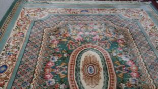 A Chinese carpet with central floral and laurel leaf medallion on jade ground with profuse foliate