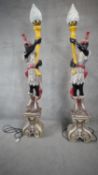 A pair of floor standing carved and painted polychrome blackamoor lamps each figure holding a