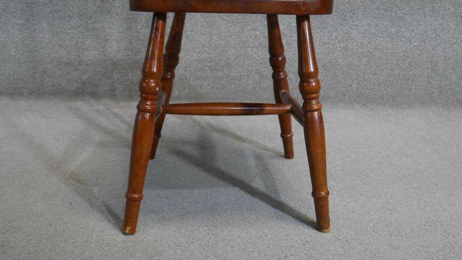 A set of four stained pine Windsor wheelback dining chairs. - Image 4 of 5