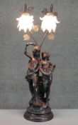 A figural bronze effect table lamp with frosted glass flower design shades. H.79 Diam.29cm