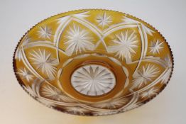 A vintage large Bohemian amber cut to clear glass bowl with a star and floral design. Diam.33cm