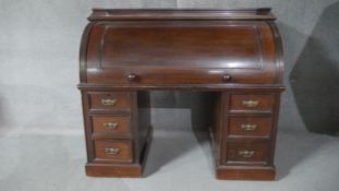 A mid 19th century three section mahogany cylinder topped bureau revealing fitted interior and