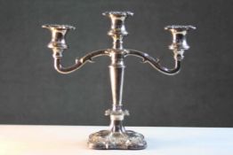A three branch silver plated candelabra with repousse vine and grape detailing. H.26 W.30 cm.