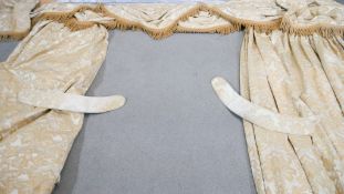 A pair of gold silk velour foliate design curtains with pelmet and tie backs. Silk tassel edging