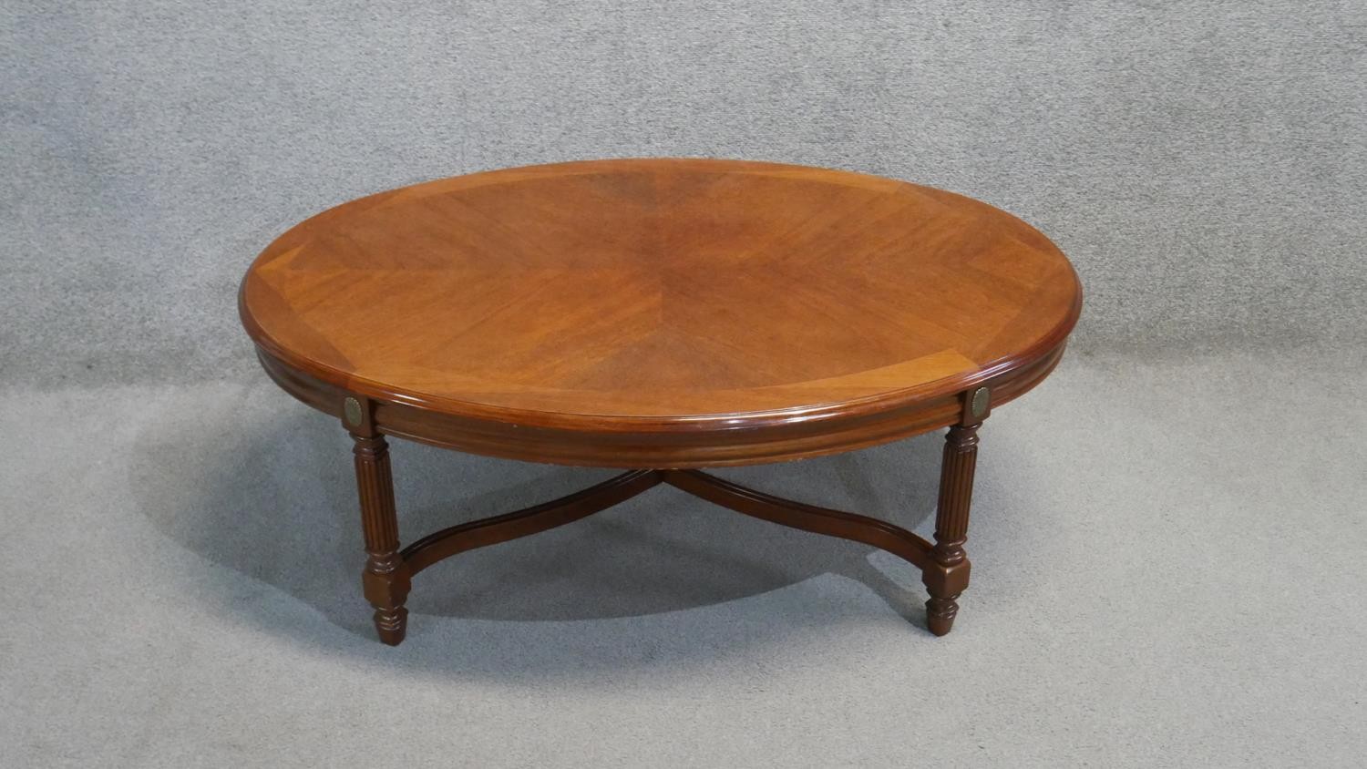 A Continental walnut and crossbanded low table on reeded stretchered supports. H. 44 W. 110 D.75