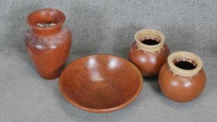 A collection of four terracotta effect ceramic pieces. Including a large fruit bowl and two urn