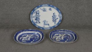 Three large blue and white ceramic oval meat platters. One Woods Tsing pattern platter with Oriental