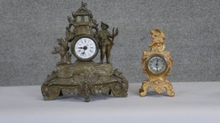 Two gilt decorative mantle clocks. One with figural decoration and a white enamel dial with Roman