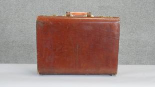 A vintage tan leather brief case with multi partitioned ostrich skin interior and brass hardware.