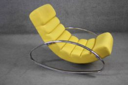 A contemporary vintage style rocking chair in fabric upholstery on chrome base.