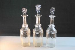 Three 19th century hand cut faceted glass decanters with stoppers, two original hexagonal blown