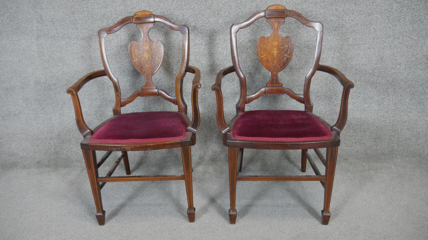 A pair of late 19th century rosewood armchairs with satinwood swag and urn inlay on square