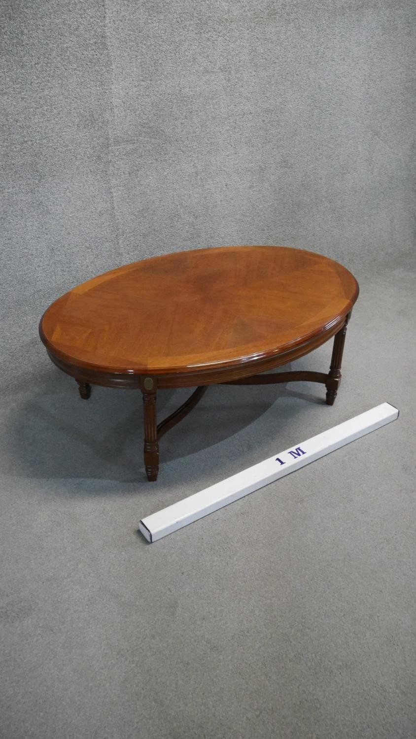 A Continental walnut and crossbanded low table on reeded stretchered supports. H. 44 W. 110 D.75 - Image 3 of 4