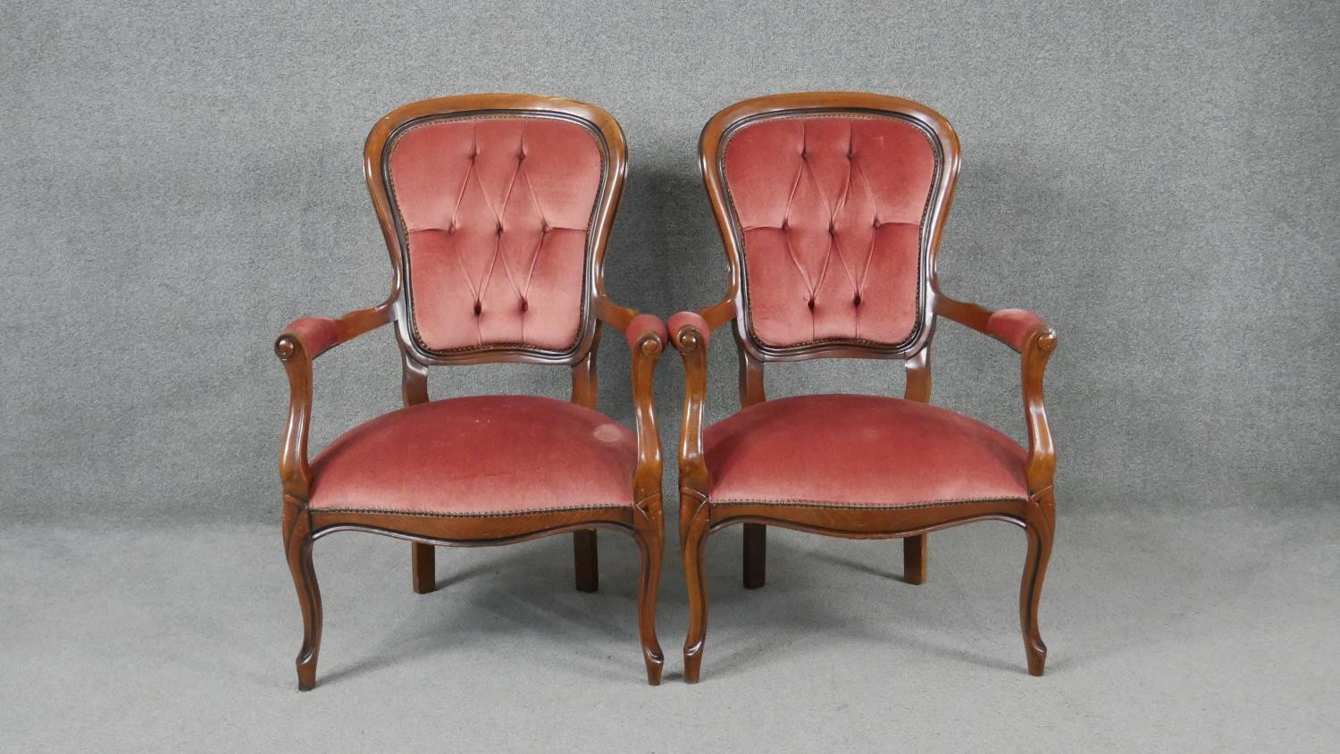 A pair of Continental style armchairs in buttoned velour upholstery on cabriole supports.