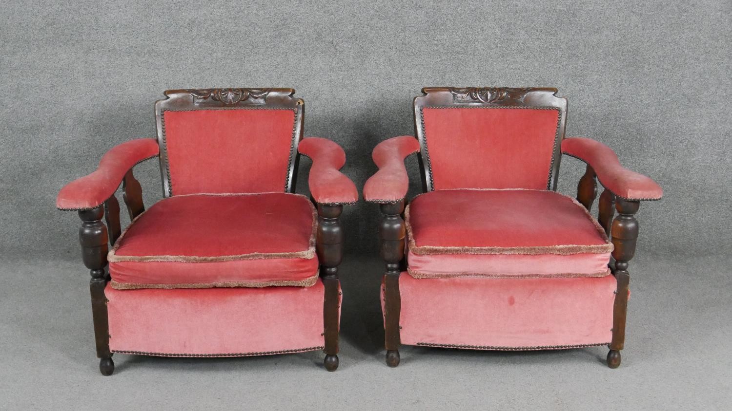 A pair of mid century oak framed armchairs in rose velour upholstery.