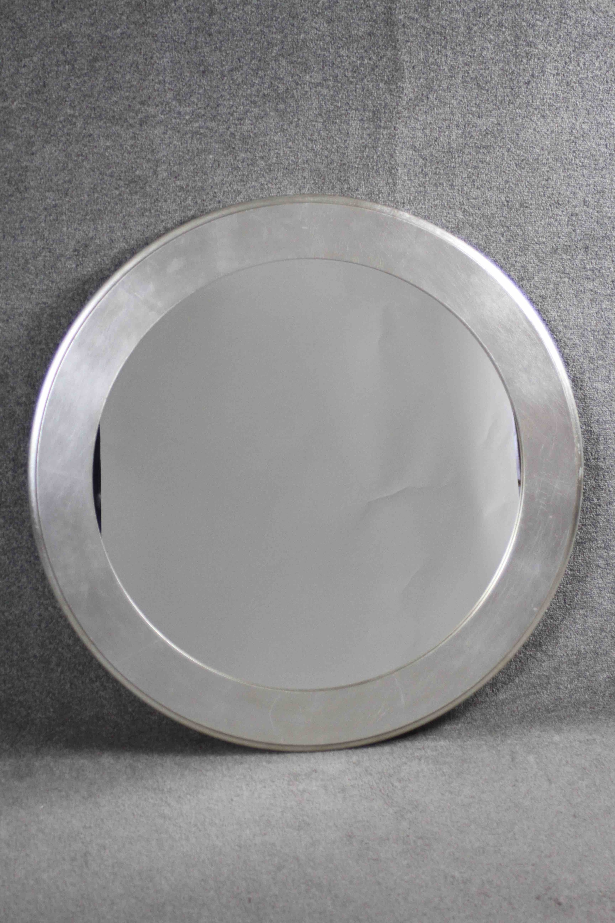 A contemporary wall mirror in moulded silvered frame. 90 cm diameter