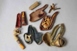 A collection of antique carved pipes and cheroot holders. One in the form on an old man, one as an