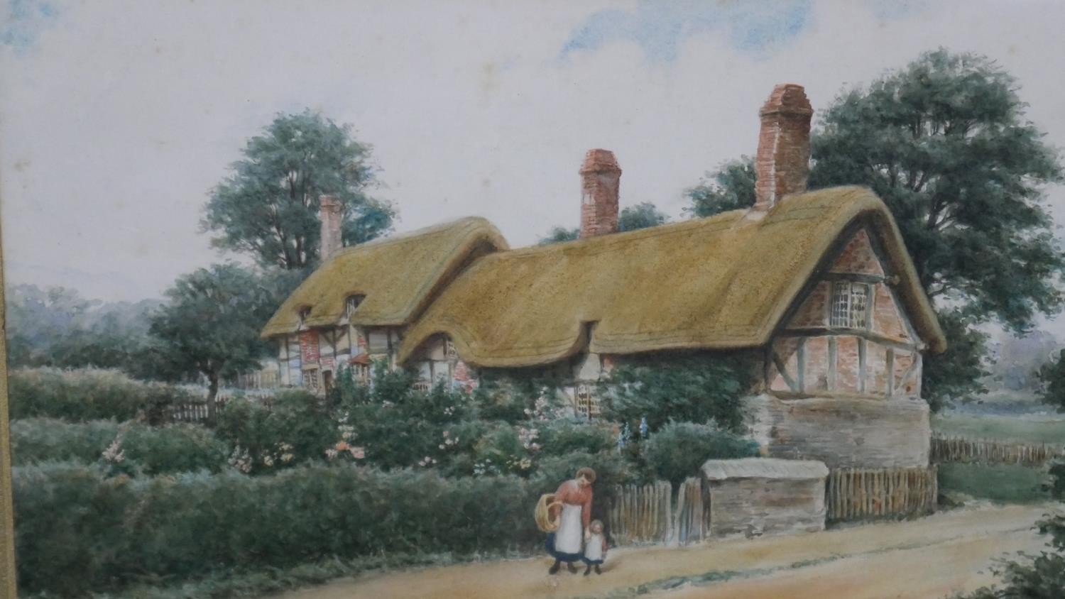 Reginald E Edgecombe- A framed and glazed watercolour of a row of thatched cottages. Signed by