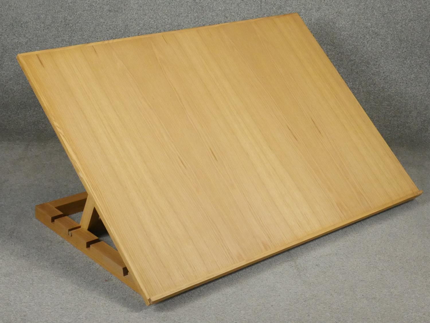 A modern light oak table top adjustable draughtsman's or architects's drafting table. H.84 W.120cm