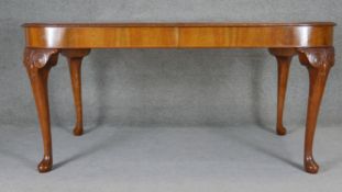 A mid century burr walnut extending dining table on carved cabriole supports. H.78 W.166 D.90