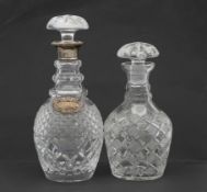 Two cut crystal decanters. One with a silver collar and silver repousse foliate design whisky