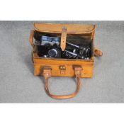 A brown leather shoulder bag containing various lenses and scientific equipment parts for